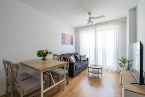 ein Wohnzimmer mit einem blauen Sofa und einem Tisch in der Unterkunft HM • Stylish 1BR Escape, City Quick in Wien