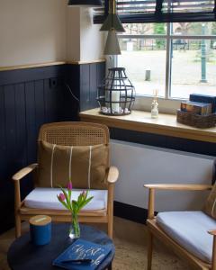 ein Wohnzimmer mit einem Stuhl und einem Tisch in der Unterkunft Bed en Baguette in Burgh Haamstede