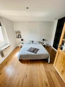 a bedroom with a bed and a wooden floor at Le Grenier in Sospel