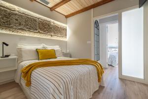 sypialnia z łóżkiem z żółtą poduszką w obiekcie Apartamento Almuiña w mieście Marín