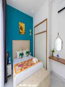 a bedroom with a bed with a blue wall at Chuỗi Villa 12 Ngủ - Trung Tâm Bãi Cháy in Ha Long