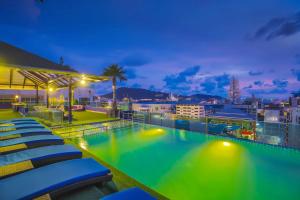 a swimming pool on the roof of a building at night at Sira Grande Hotel & Spa in Patong Beach