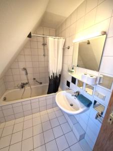 bagno con lavandino, vasca e specchio di Zauberhaft übernachten - nur ~7 min. vom Europa-Park a Ettenheim