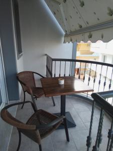 y balcón con mesa y sillas de madera. en EvropisHouse en Kozani