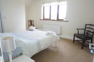 Holywell Lodge : غرفة نوم بسرير وكرسي ونافذة