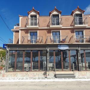 ein großes Gebäude mit Glasfenstern und Balkonen in der Unterkunft Medusa Apartments in Kateliós