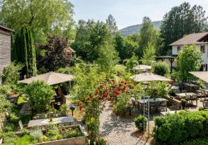 un jardín con mesas, sombrillas y flores en Hotel Gasthof Kammbräu, en Zenting