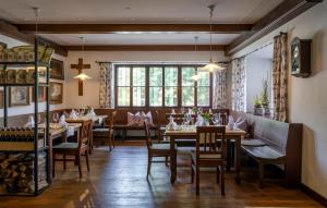 a restaurant with wooden tables and chairs and a large window at Hotel Gasthof Kammbräu in Zenting