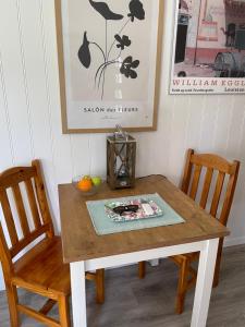 a dining room table with two chairs and a table with a vase at Tiny house Lund in Lund