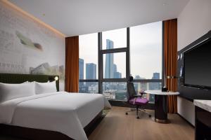 深セン市にあるHampton by Hilton Shenzhen Nanshan Science and Technology Parkのベッドと大きな窓が備わるホテルルームです。
