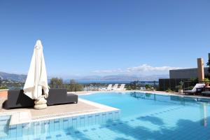 a swimming pool with an umbrella on top of a building at Casa T with amazing views in Corfu in Kontokali