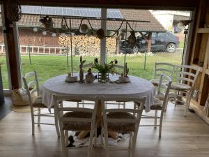 - une table à manger avec une nappe et des chaises blanches dans l'établissement Escale sur la Côte, à Porrentruy