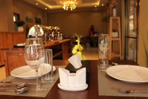 a table with glasses and plates on a table at Hotel Samye - Best Hotel In Thimphu in Thimphu