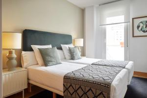 une chambre avec un grand lit avec une tête de lit bleue dans l'établissement Muinoa 2 by FeelFree Rentals, à Saint-Sébastien