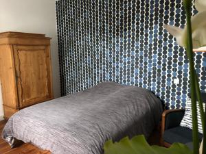 1 dormitorio con 1 cama y armario de madera en La Sirène, en Grand-Village-Plage