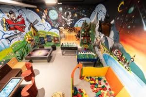 una sala de juegos para niños con un mural en la pared en Hotel Watles en Malles Venosta