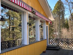 a yellow building with windows on a deck at Enonkosken Kartano & Guesthouse in Enonkoski