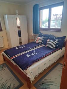 een slaapkamer met een bed met blauwe dekens en kussens bij Veronika Panoráma Villa in Paloznak