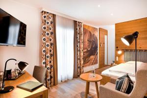ein Hotelzimmer mit einem Bett, einem Schreibtisch und einem Tisch in der Unterkunft Hotel Gasthof Kammbräu in Zenting