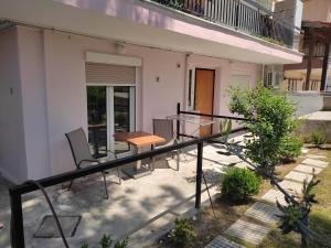 einen Balkon eines Hauses mit einem Tisch und Stühlen in der Unterkunft Sophia's Home near the sea - Olivia Studios in Agía Triás