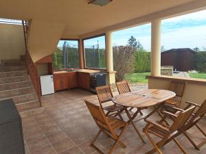 een patio met een tafel en stoelen en een keuken bij Veronika Panoráma Villa in Paloznak