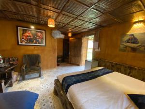a bedroom with a bed and a chair in it at Ha Giang Xanh Retreat, Tour and Motorbike Rental in Ha Giang