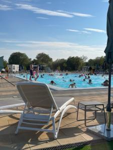 a pool with a chair and people in the water at Bull Rush Retreats luxury hot tub lodge at Tattershall Lakes in Tattershall