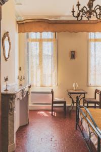 - un salon avec une table, des chaises et des fenêtres dans l'établissement Maison Pelissier - Chambres d’hôtes avec piscine, à Cuxac-dʼAude