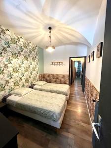2 camas en una habitación con flores en la pared en Appartement terrasse vue lac, en Breil-sur-Roya