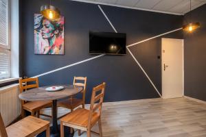 comedor con mesa, sillas y TV en Keja Rooms II - Pokoje Noclegi w Centrum Gdyni en Gdynia