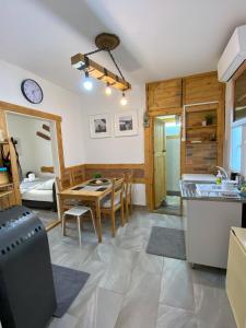 uma cozinha e sala de jantar com uma mesa e uma cozinha e um quarto em Amur Vendégház em Gárdony