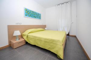 a bedroom with a bed with a yellow blanket at RESIDENCE TWIGHA in Martinsicuro