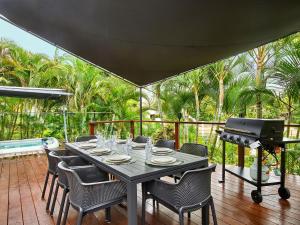 a table with chairs and a grill on a patio at Luxurious home with pool and Water views in Gold Coast