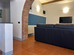 sala de estar con sofá y TV en Villa Mucellena, en Casole dʼElsa