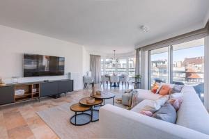 sala de estar con sofá y TV en Bright and spacious apartment with stunning views!, en Knokke-Heist