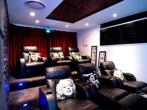 a movie room with leather chairs and a room with at Luxurious home with pool and Water views in Gold Coast
