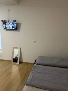 a bedroom with a bed and a tv on the wall at Bodensee Apartments in Friedrichshafen