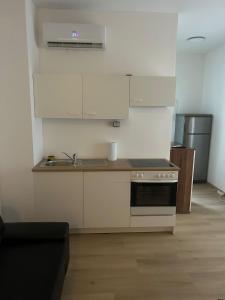 a kitchen with white cabinets and a stove top oven at Bodensee Apartments in Friedrichshafen