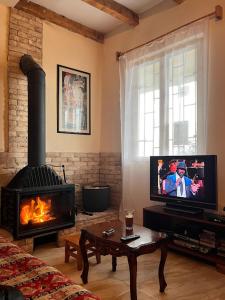a living room with a fireplace and a flat screen tv at Villa Rbona in Khashuri