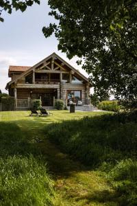 ein großes Blockhaus mit einer Veranda auf einem Rasen in der Unterkunft Beautiful log home with stunning views in Zottegem