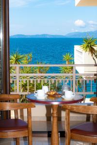 a table on a balcony with a view of the ocean at Ostrella Hotel - Luxury rooms in Mýtikas