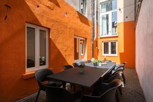 une table et des chaises dans une pièce avec un mur orange dans l'établissement Huswell - Beautiful and spacious vacation home with parking, à Blankenberge
