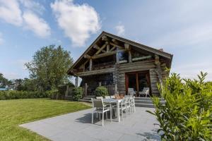 Cabaña de madera con mesa y sillas en el patio en Beautiful log home with stunning views en Zottegem