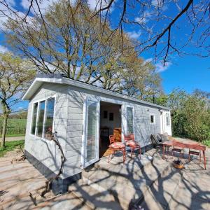 une petite maison avec deux chaises et une table dans l'établissement Wijnstaete, à Lemelerveld