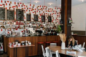 une femme assise à une table dans un restaurant dans l'établissement Huswell - The Jungle' Studio in the heart of Ghent, à Gand