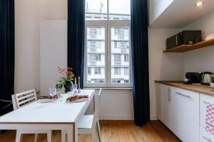 a kitchen with a white table and a large window at 'The Jungle' Studio in the heart of Ghent in Ghent