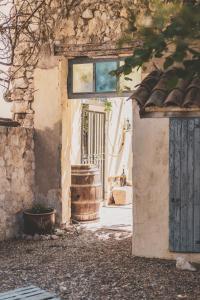 un accès à un bâtiment avec une porte et un tonneau dans l'établissement Maison Pelissier - Chambres d’hôtes avec piscine, à Cuxac-dʼAude