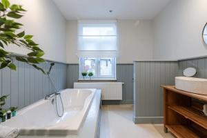 a bathroom with a tub and a window at Authentic townhouse near the beach of Blankenberge in Blankenberge