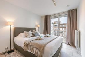 een slaapkamer met een groot bed met een groot raam bij Huswell - Apartment on prime location in Knokke in Knokke-Heist