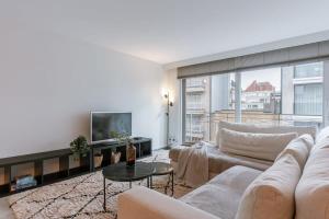 een woonkamer met een bank en een tv bij Huswell - Apartment on prime location in Knokke in Knokke-Heist